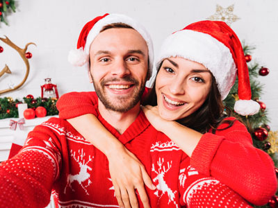 un homme et une femme avec bonnet et pull de Noël